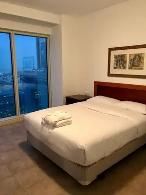 a bedroom with a bed and a large window at Private Rooms in CoLiving Apartments UP Tower DIFC in Dubai