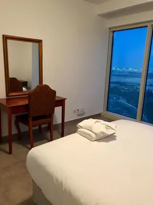 a bedroom with a bed and a desk and a mirror at Private Rooms in CoLiving Apartments UP Tower DIFC in Dubai