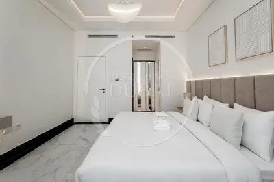 a white bedroom with a large bed with white pillows at Luxury 2Bdr Apartment in Business Bay in Dubai