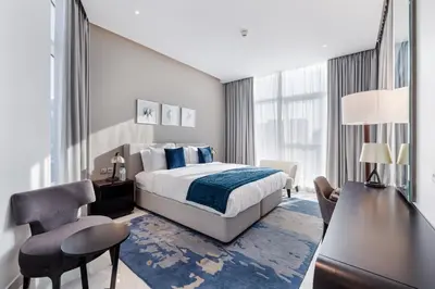 a bedroom with a bed and a desk and a chair at Modern 2-Bedroom Apartment Near Burj Khalifa & Dubai Mall in Dubai