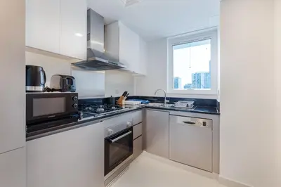 a kitchen with stainless steel appliances and a window at Modern 2-Bedroom Apartment Near Burj Khalifa & Dubai Mall in Dubai