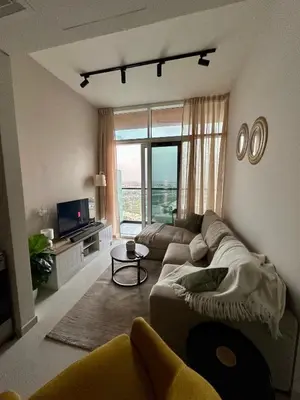 a living room with a couch and a large window at Cozy Golf & Lake View 1BR Apartment,Damac Hills 1 in Dubai