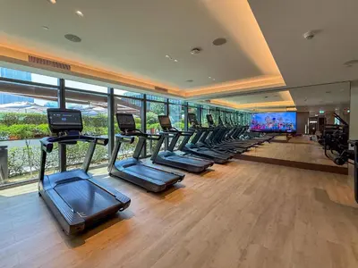 a gym with a row of treadmills in a building at Frank Porter - Address Opera in Dubai