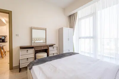 a bedroom with a bed and a desk and a mirror at Superhost - Bright & Stylish 1-Bedroom in Bloom Tower, JVC in Dubai