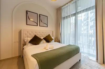 a bedroom with a large bed with a large window at HAVN - 1 Bedroom in Harrington House, JVC in Dubai
