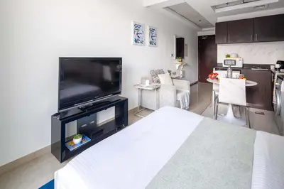 a living room with a large flat screen tv at Frank Porter - Hanover Square in Dubai