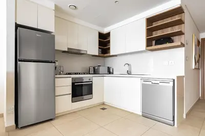 a kitchen with white cabinets and stainless steel appliances at downtown views 1108 burj in Dubai