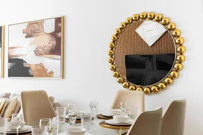 a dining room with a table and a gold mirror at downtown views 1108 burj in Dubai