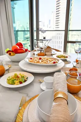 a white table with plates of food on it at Trendy 2BR Direct Mall Access Burj View High Floor in Dubai