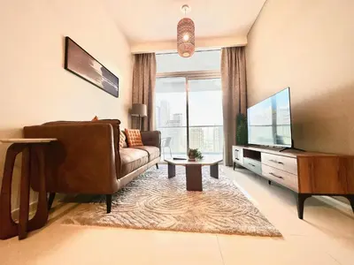 a living room with a couch and a flat screen tv at Sleek & Spacious 2BR in DAMAC Vera, Business Bay by Bhavan Vacation Homes in Dubai
