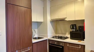 a small kitchen with a sink and a microwave at Sleek & Spacious 2BR in DAMAC Vera, Business Bay by Bhavan Vacation Homes in Dubai