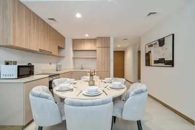 a kitchen and dining room with a table and chairs at Modern 2BR Canal-Side Elegance in Dubai