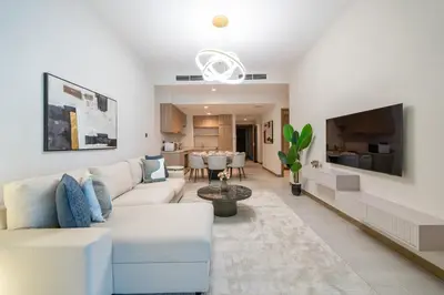 a living room with a white couch and a tv at Modern 2BR Canal-Side Elegance in Dubai