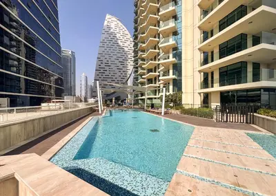 a swimming pool on the roof of a building with tall buildings at Modern 2BR Canal-Side Elegance in Dubai