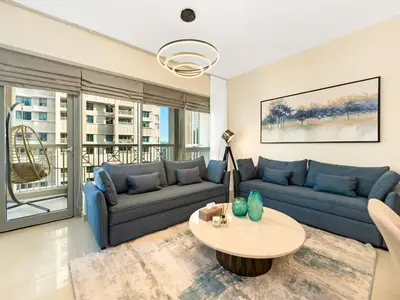 a living room with a blue couch and a table at Royal Vista - Luxury 3BR Apartment at 29 Boulevard Tower - Downtown in Dubai