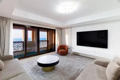 a living room with a tv and a couch and a table at Charming Sea View 2BDR, Beach and Pool Access in Dubai