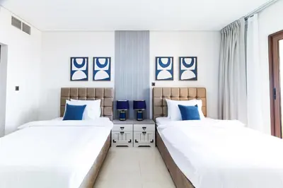 two beds in a bedroom with blue and white at Charming Sea View 2BDR, Beach and Pool Access in Dubai