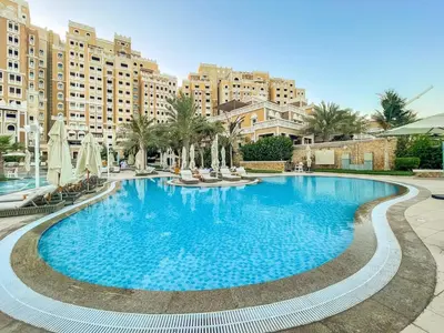 a large swimming pool in a resort with buildings at Charming Sea View 2BDR, Beach and Pool Access in Dubai