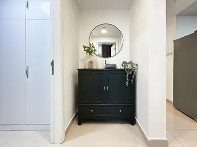 a dark green cabinet in a hallway with a mirror at Trophy - Luxury Waterfront 2BR with Big Terrace Full Marina Canal Views in Dubai