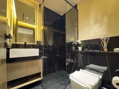 a bathroom with a toilet and a glass shower at Sunset View Overlooking Burj Khalifa and Canal View in Dubai