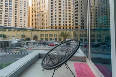 a chair on a balcony with a view of a city at White Sage Spacious 1BR at Marina Promenade in Dubai
