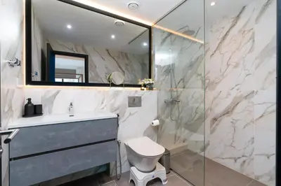 a bathroom with a shower and a toilet and a sink at White Sage Spacious 1BR at Marina Promenade in Dubai