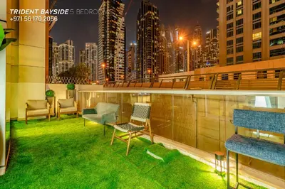 a balcony with green grass and chairs on a building at Usmans Brand New Duplex Apartment 5 Bedrooms Dubai Marina Trident Bayside 4 Rooms with 4 En-suite Washrooms in Dubai