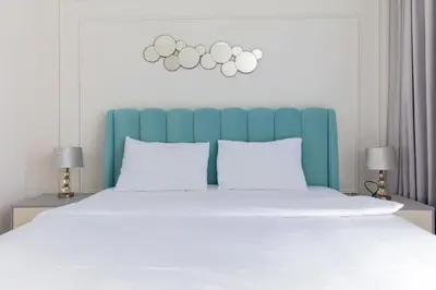 a bed with a blue and white headboard and two lamps at 2BDR Apartment in Bluewaters Luxury Area in Dubai