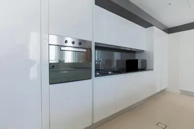 a kitchen with white cabinets and a stainless steel oven at 2BDR Apartment in Bluewaters Luxury Area in Dubai