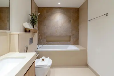 a bathroom with a tub and a toilet and a sink at 3 Bedrooms Apartment in Downtown Views - Dubai Burj Khalifa View in Dubai