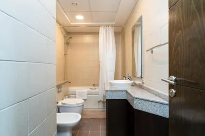 a bathroom with a toilet and a sink and a mirror at Classy Upgraded - High Floor - Prime Location in Dubai