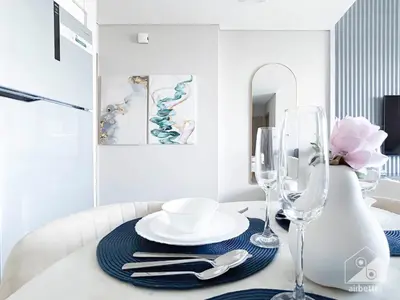 a dining room table with a plate and two wine glasses at Burj Royale Luxury One-Bedroom with City Views in Dubai