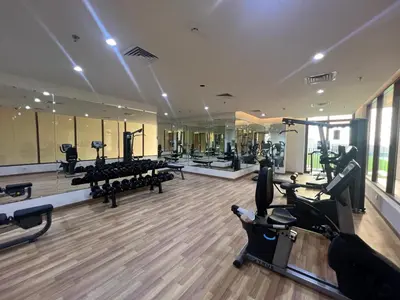 a gym with treadmills and elliptical machines in a room at White Sage New Large 1BR at JVC in Dubai