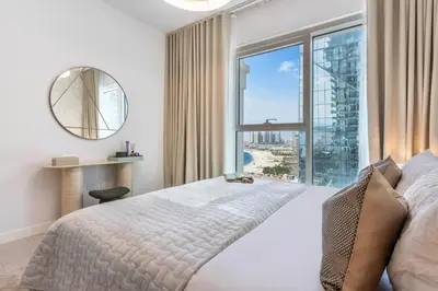 a bedroom with a large bed and a large window at Ultra-Luxury 2BR at La Vie Iconic Sea Views in Dubai