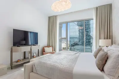a bedroom with a large bed and a large window at Ultra-Luxury 2BR at La Vie Iconic Sea Views in Dubai