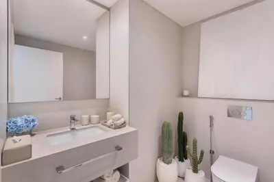a bathroom with a sink and a toilet and a mirror at Ultra-Luxury 2BR at La Vie Iconic Sea Views in Dubai