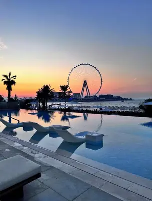 a large swimming pool with a ferris wheel in the background at Ultra-Luxury 2BR at La Vie Iconic Sea Views in Dubai