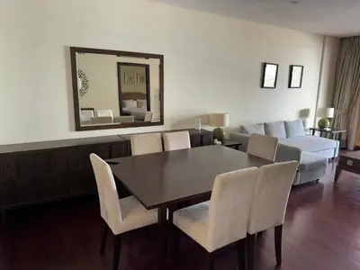 a dining room with a table and chairs and a couch at Royal Amwaj-Anantara residence South in Dubai