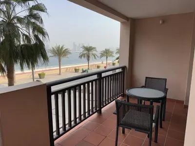 a balcony with a table and chairs and a view of the beach at Royal Amwaj-Anantara residence South in Dubai