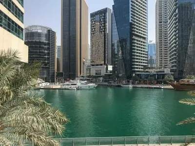 a river with boats in a city with tall buildings at Frank Porter - Marina Quays East Tower in Dubai