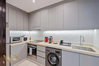 a kitchen with a washing machine and a sink at Marcopolo - Experience luxury living with lake views in JLT in Dubai
