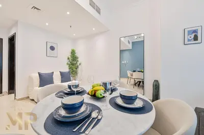 a dining room with a table with plates and utensils at Marcopolo - Experience luxury living with lake views in JLT in Dubai