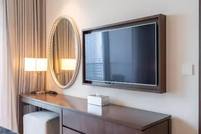 a large flat screen tv on a wall in a hotel room at Downtown Elegance - 1BR Apartment with Unmatched Burj Khalifa Views in Dubai