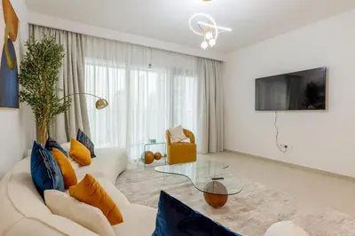 a living room with a white couch and a glass table at 3 Bedroom - Burj Khalifa View, Downtown Views II in Dubai