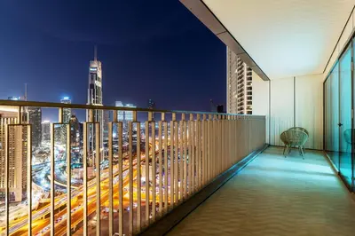 a balcony with a view of a city at night at 3 Bedroom - Burj Khalifa View, Downtown Views II in Dubai