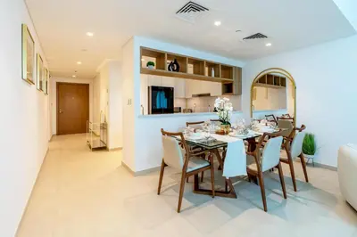 a dining room and kitchen with a table and chairs at 3 Bedroom - Burj Khalifa View, Downtown Views II in Dubai