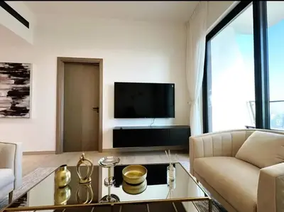 a living room with a couch and a tv at Binghatti Heights JVC in Dubai