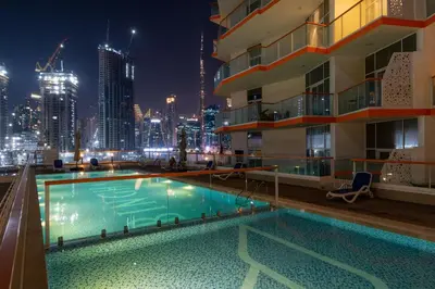 a pool on the roof of a building at night at Stunning Waterfront Burj Views with Pool & Gym, Sleeps 6 in Dubai