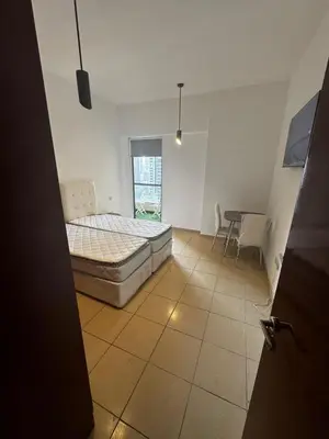 a bedroom with a bed and a table in it at TWIN BED-ROOM Sadaf Community near TRAM in Dubai