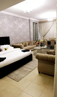 a hotel room with a bed and a living room at Luxury Apartment by oima leasing property in Dubai